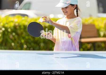 Bambina che gioca a ping pong nel parco. Foto Stock