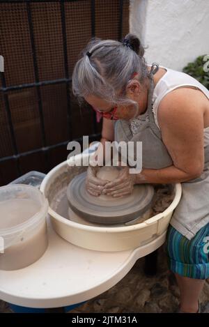 Frigiliana, Malaga, 27 agosto 2022: potter lavora con la ruota di un vasaio in una strada a Frigiliana in occasione del Festival delle tre Culture Foto Stock