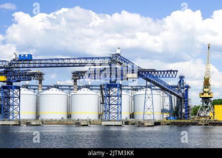 Terminale per grano versatile con molti silos di stoccaggio nel porto di Ventspils per il trasferimento di una vasta gamma e quantità di prodotti agricoli Foto Stock