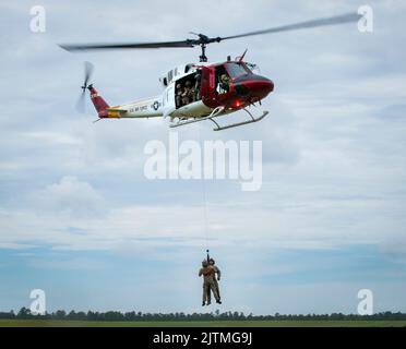 Uno Squadron di prova di volo 413th UH-1 Huey solleva due Airmen di Squadron di 20th di operazioni di supporto dell'aria nell'aria sopra Eglin Air Force base, Florida 23 agosto. Il 413th FLTS, l’unica unità di test per lo sviluppo di alari rotanti dell’Air Force, ha fornito un ulteriore realismo all’addestramento per l’estrazione di Airmen, il partito tattico per il controllo dell’aria. (STATI UNITI Foto dell'aeronautica/Samuel King Jr.) Foto Stock