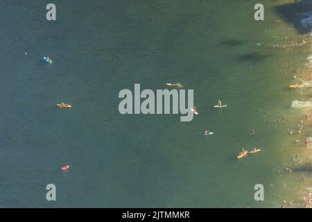 Persone che praticano Stand up paddle sulla spiaggia rossa visto dalla cima del Morro da Urca a Rio de Janeiro Brasile. Foto Stock