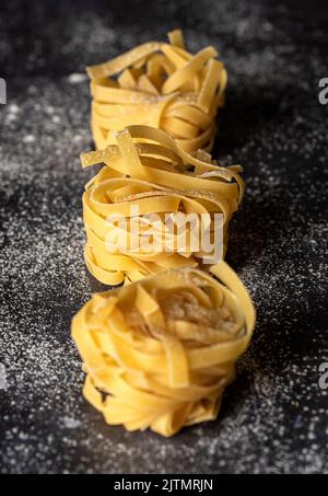 Fotografia alimentare di pasta cruda, tagliatelle, fettuccine, macro Foto Stock