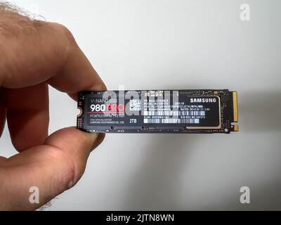 Parigi, Francia - 8 agosto 2022: Mano POV maschio disimballaggio disimballaggio nuovo Samsung 980 Pro NVME ss disco rigido per il personal computer o mac aggiornamento Apple Foto Stock