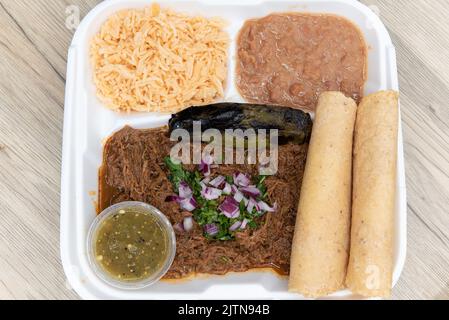 Vista dall'alto della generosa porzione di carne di birria cotta lentamente, servita con tortilla di mais, riso, fagioli e salsa per un pasto allettante. Foto Stock