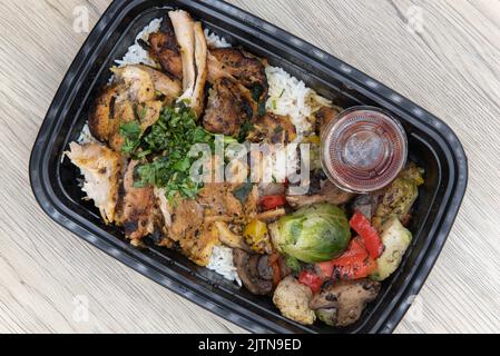 Vista dall'alto del pollo shawarma da aspare con riso jasmin è comodamente confezionato in un contenitore per microonde. Foto Stock
