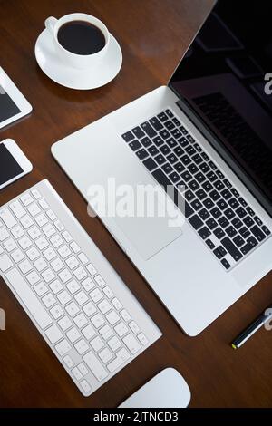 I moderni accessori per l'ufficio. Ripresa ad angolo elevato di vari dispositivi digitali su un tavolo. Foto Stock