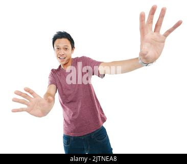 Porto entusiasmo a tutto quello che faccio. Studio ritratto di un giovane uomo che si allunga con le mani su uno sfondo bianco. Foto Stock