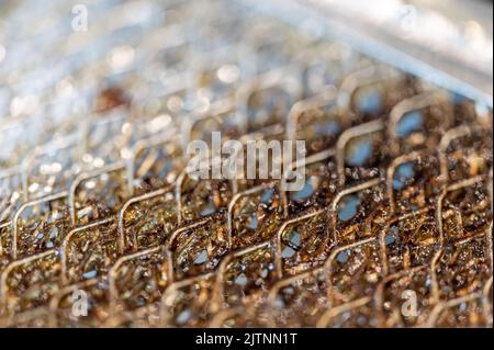 Macro di messa a fuoco selettiva di un filtro sporco cappa gamma cucina intasato di grasso. Foto Stock