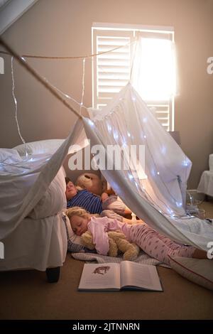 Stretto e si stabilì in un sognante. Fratelli dormendo sotto un forte coperta a casa. Foto Stock