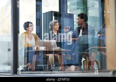 I team di successo si costruiscono a vicenda. Un team di uomini d'affari creativi che si intrometta nel brainstorming intorno a un notebook in ufficio. Foto Stock