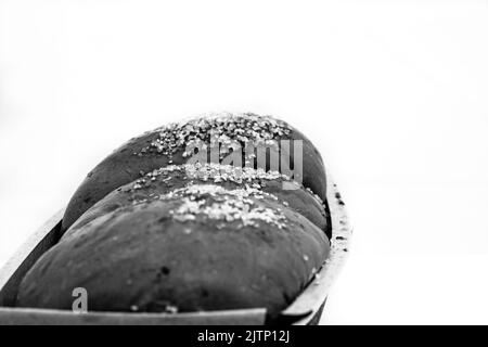 Un primo piano in scala di grigi di un pane Cozonac dolce appena sfornato con sfondo bianco Foto Stock