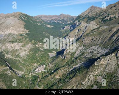 VISTA AEREA. Piccolo villaggio nella Valle Tinée ai piedi del Parco Nazionale del Mercantour. Alpes-Maritimes, Provence-Alpes-Côte d'Azur, Francia. Foto Stock