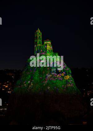 Proiezione di luce su una cappella arroccata su un collo vulcanico. Aiguilhe, alta Loira, Auvergne-Rhône-Alpes, Francia. Foto Stock