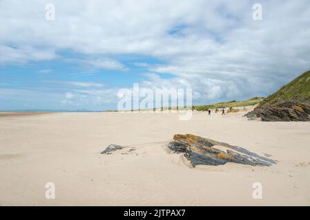 Camminatori sulla spiaggia a Morfa Bychan vicino Porthmadog sulla costa del Galles del Nord. Foto Stock