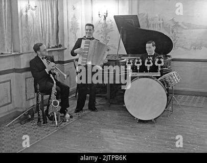 Una band di danza britannica, il W Johnson Trio, presso l'Unity Hall di Brixton, Londra, Regno Unito nel gennaio 1938. Le prime band dance e swing hanno avuto il loro massimo splendore nel Regno Unito negli anni 1920s-30s. Band suonate nelle sale da ballo e nelle sale da ballo dell'hotel. Hanno suonato musica melodica e di buon tempo e i singoli giocatori suonavano in diverse band. Questa immagine proviene da un vecchio vetro negativo - una fotografia vintage 1930s. Foto Stock