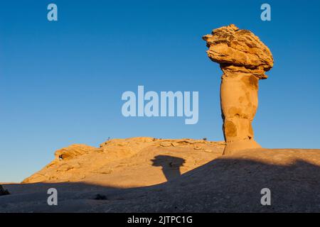 Il volto della guglia segreta, un hoodoo di arenaria su una cupola di arenaria Navajo nel deserto vicino a Moab, Utah. Dietro si trova un piccolo arco. Foto Stock