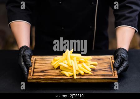 fast food patatine fritte salate bordo di legno Foto Stock