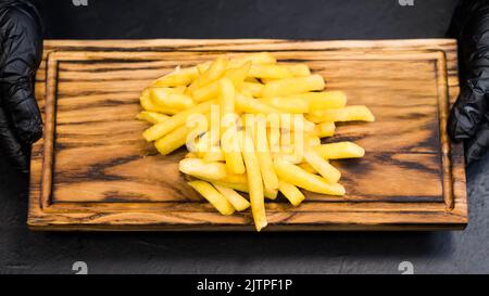 fast food patatine fritte salate bordo di legno Foto Stock