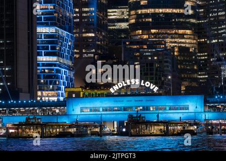 Un cartello Endless Love sopra la stazione ferroviaria di Circular Quay e molti degli edifici dietro di essa sono illuminati per il Vivid Sydney 2022 Festival in Australia Foto Stock