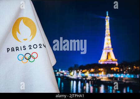 PARIGI, FRANCIA, AGOSTO 8. 2022: Giochi olimpici estivi Parigi 2024 sfondo nero. Logo ufficiale di SOG 2024 a Parigi su coperta bianca con T Eiffel scura Foto Stock