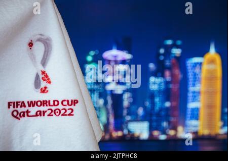 DOHA, QATAR, 30 AGOSTO 2022: Logo della Coppa del mondo FIFA Qatar 2022 e skyline notturno di Doha sullo sfondo. Coppa del mondo di calcio Qatar 2022 carta da parati e bla Foto Stock