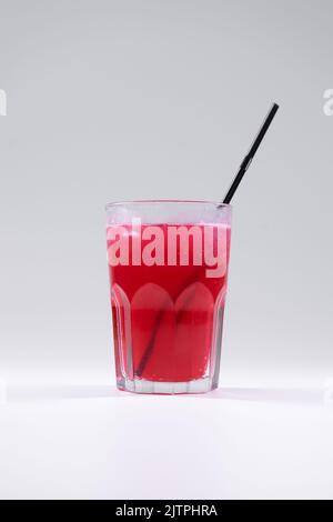 bevanda fresca di frutta fredda con succo d'uva rosso, ghiaccio, paglia isolata Foto Stock