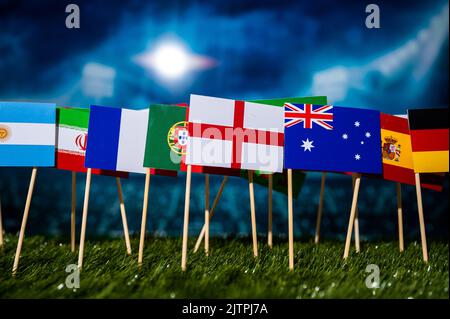 Bandiera nazionale dell'Inghilterra e altri bandiere dei paesi di calcio su erba verde. Sfondo sportivo per il torneo in Qatar Foto Stock