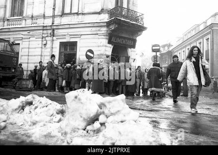 Bucarest, Romania, gennaio 1990. Meno di un mese dopo la rivoluzione anticomunista del dicembre 1989, la gente rimane ancora in lunghe file per ottenere la presa dei generi alimentari di base. Il sistema economico socialista centralizzato ha creato scarsità e fame. Foto Stock