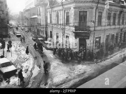 Bucarest, Romania, gennaio 1990. Meno di un mese dopo la rivoluzione anticomunista del dicembre 1989, la gente rimane ancora in lunghe file per ottenere la presa dei generi alimentari di base. Il sistema economico socialista centralizzato ha creato scarsità e fame. Foto Stock