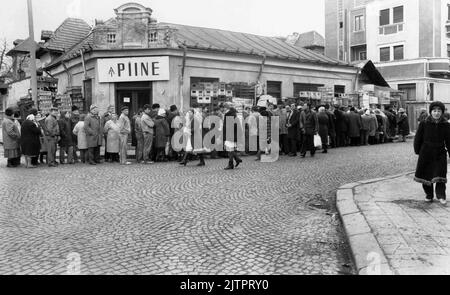 Bucarest, Romania, gennaio 1990. Meno di un mese dopo la rivoluzione anticomunista del dicembre 1989, la gente rimane ancora in lunghe file per ottenere la presa dei generi alimentari di base. Il sistema economico socialista centralizzato ha creato scarsità e fame. Qui, una linea di fronte a un negozio di pane. Foto Stock