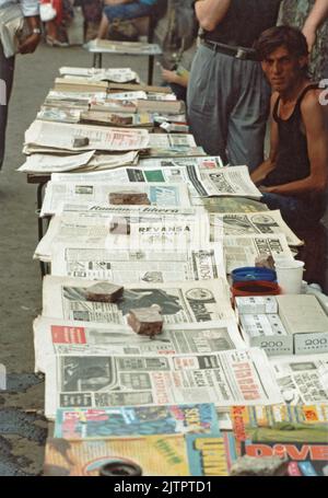 Bucarest, Romania, 1990. Uomini che vendono giornali e riviste per strada. Nei mesi successivi alla rivoluzione rumena del 1989, in Romania c'era sete di informazioni e molte nuove riviste e giornali venivano pubblicati. Foto Stock