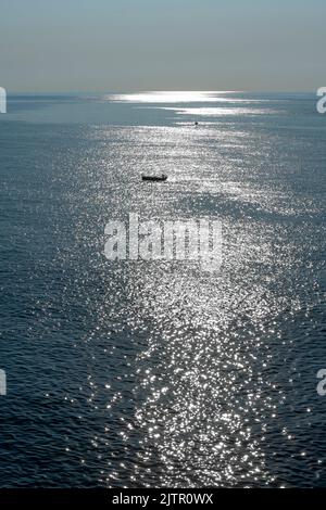 Pesca mattutina nelle acque blu del Mar Ionio ad Aci Castello, un villaggio di pescatori sulla costa siciliana vicino Catania Foto Stock