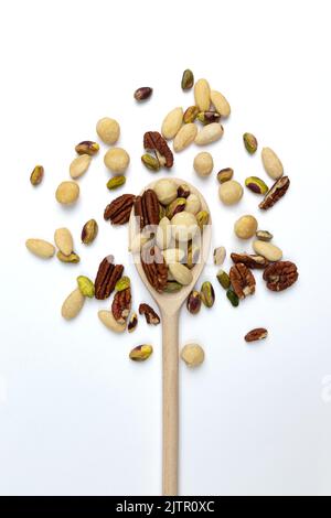 noci miste in cucchiaio di legno isolato su sfondo bianco, vista dall'alto, pistacchio sbucciato, macadamia, mandorle, nocciole e noci pecan, snack sano Foto Stock