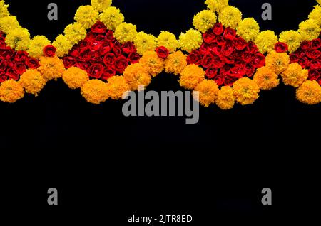 Rangoli decorativi di fiori di rosa e marigold per la festa di Diwali su sfondo nero. Foto Stock