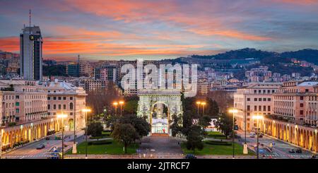 Genova, Italia parco e arco trionfale tra il paesaggio urbano all'alba. Foto Stock