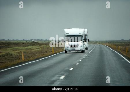 Islanda, Sudurland - 8th agosto 2022 - camper bianco, RV guida su una strada - vista frontale Foto Stock