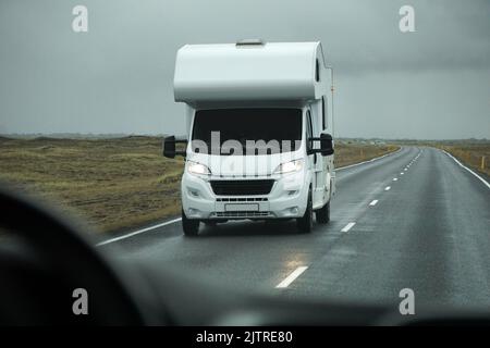 Islanda, Sudurland - 8th agosto 2022 - camper bianco, RV guida su una strada - vista frontale Foto Stock