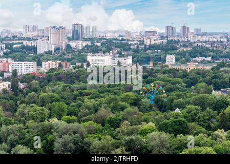 Il paesaggio urbano di Kiev con area verde e vecchia ruota panoramica in primo piano Foto Stock