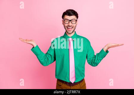 Primo piano foto di giovane bel ragazzo sorridente sorpreso con i prezzi tenendo le mani scelta migliore affare isolato su sfondo di colore rosa Foto Stock