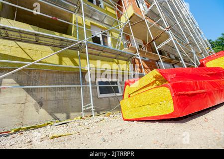 Imballaggio di materiale di isolamento termico, lana di pietra avvolta in foglio è in attesa di essere installato sulle pareti dell'edificio residenziale in costruzione Foto Stock