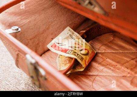 Venti reais nota (denaro brasiliano), caduto in una vecchia borsa marrone a Rio de Janeiro. Foto Stock