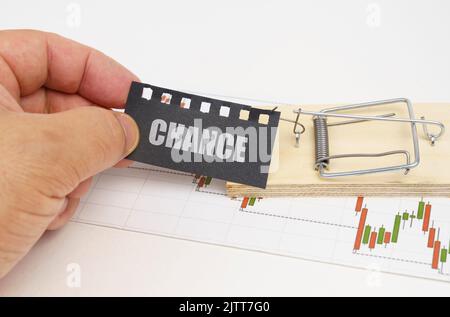 Concetto aziendale. Sul grafico del preventivo c'è un mousetrap da cui la mano tira fuori una targa nera con l'iscrizione - CHANCE Foto Stock