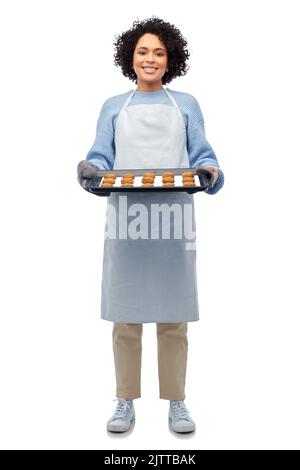 donna in grembiule con vassoio da forno e biscotti Foto Stock