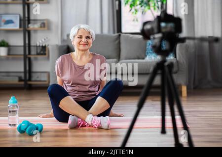 donna o fitness blogger con macchina fotografica a casa Foto Stock