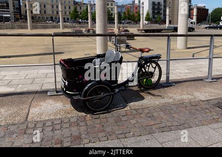 Triciclo Babboe cargo. Stile vintage. Porta bambini. Baia di Cardiff. Estate 2022 . Foto Stock