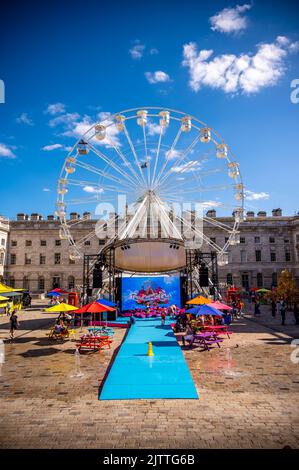 Londra, Regno Unito - 20 agosto 2022 - il cortile della Somerset House è temporaneamente pieno di effemera pubblica e intrattenimento, tra cui una ruota panoramica in c Foto Stock