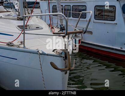 Un'ancora rialzata sulla parte anteriore dello yacht. Un primo piano dell'ancora di una barca al porto Foto Stock