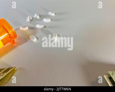 Pillole di prescrizione versato su una superficie tutta bianca - sfondo bianco con abbondanza di spazio di copia Foto Stock