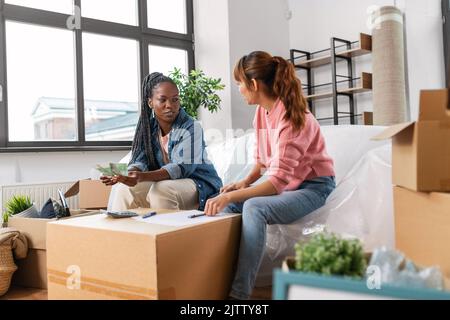 le donne che si spostano in una nuova casa e contano i soldi Foto Stock