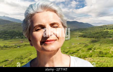 Ritratto di donna senior godendo di sole sulla spiaggia Foto Stock